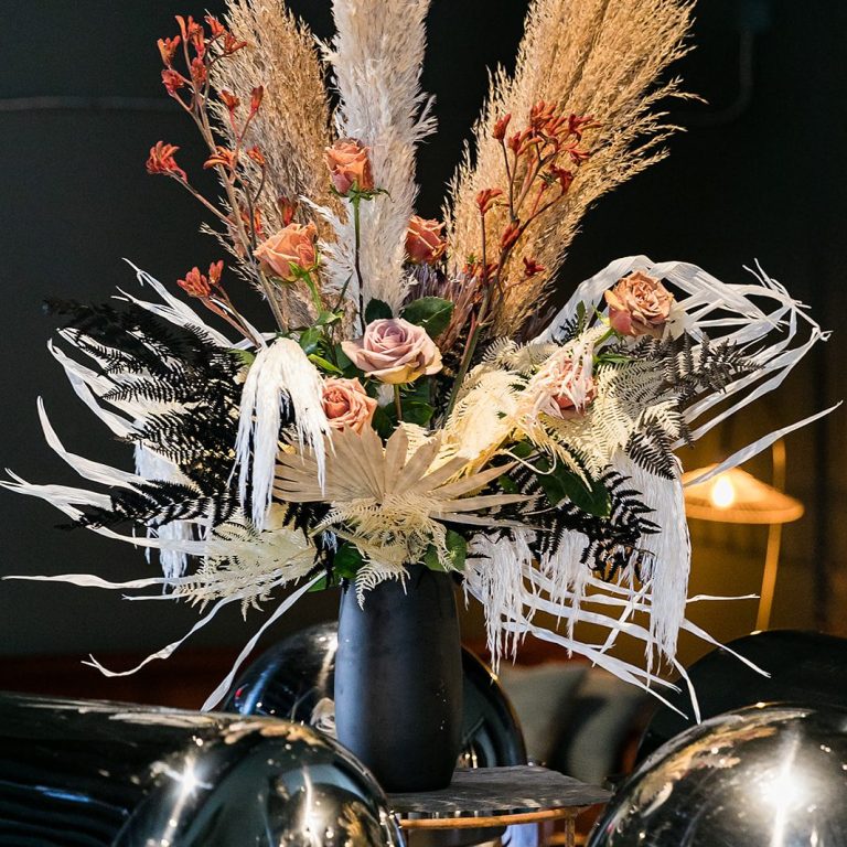 Avant-garde dark floral arrangement of deep plum peonies and dahlias